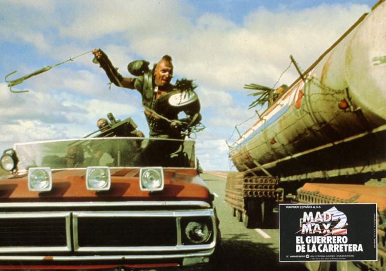 Mad Max 2 lobby card showing Wez (Vernon Wells) swinging a grappling hook