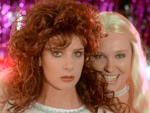 Muriel (Toni Collette) smiling behind Rhonda (Rachel Griffiths) looking sombre as the ABBA girls