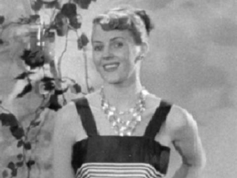 A woman is posing for the camera wearing a black and white dress.