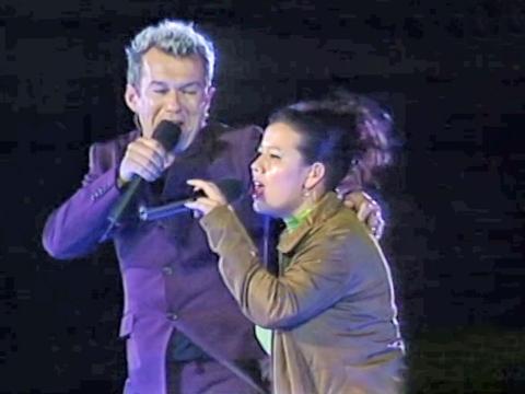 Jimmy Barnes and his daughter Mahalia Barnes on stage. They are facing toward each other and both holding microphones. 