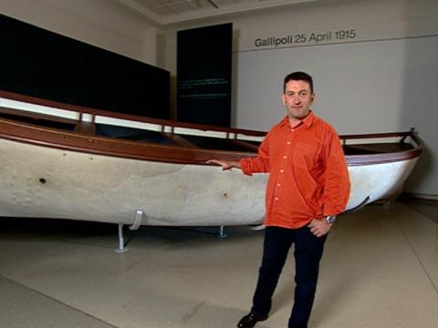 Warren Brown stands next to the Gallipoli boat in the Australian War Memorial, Canberra.