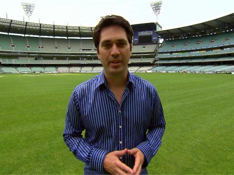 Man standing in the middle of an empty AFL stadium.