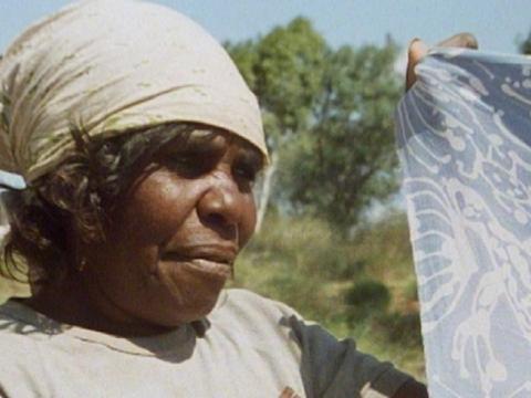 Close up of an Indigenous woman holding a batik.