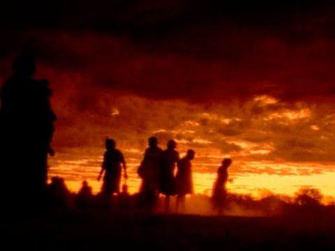 Orange night sky with the silhouettes of people against it