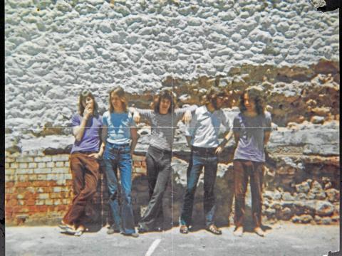The band Cold Chisel in 1973 pictured against a brick wall. From left to right are Les Kaczmarek, Steve Prestwich, Jimmy Barnes, Don Walker and Ian Moss.