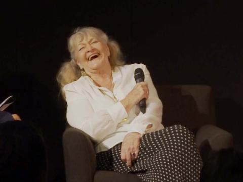 Actress Val Lehman holding a microphone and laughing during a Q&A at the NFSA