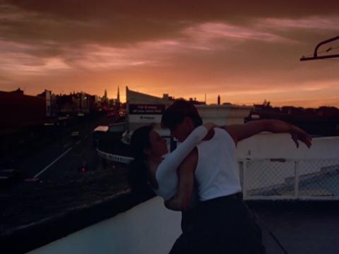 Tara Morice and Paul Mercurio embrace while dancing against a sunset backdrop in a scene from the film Strictly Ballroom