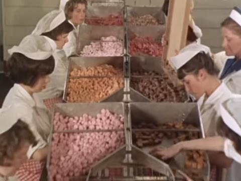 Women working in a chocolate factory, inspecting and sorting out the product
