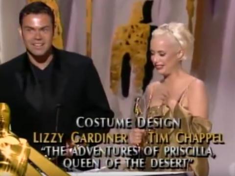 Tim Chappel and Lizzy Gardiner at the podium accepting their Best Costume Design Academy Award