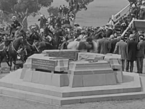 Black and white still image of monument at the naming of Canberra