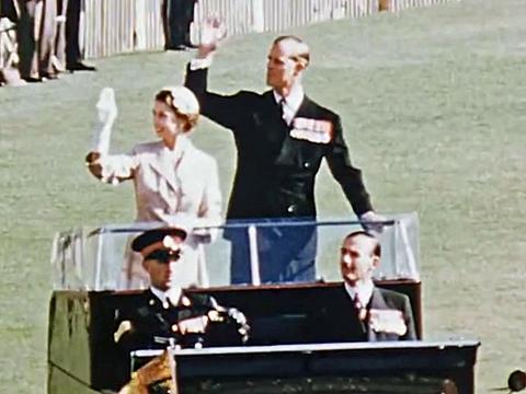 Queen Elizabeth II and Prince Philip, the Duke of Edinburgh, in the back of a car wave to crowds at the Melbourne Cricket Ground in 1954.