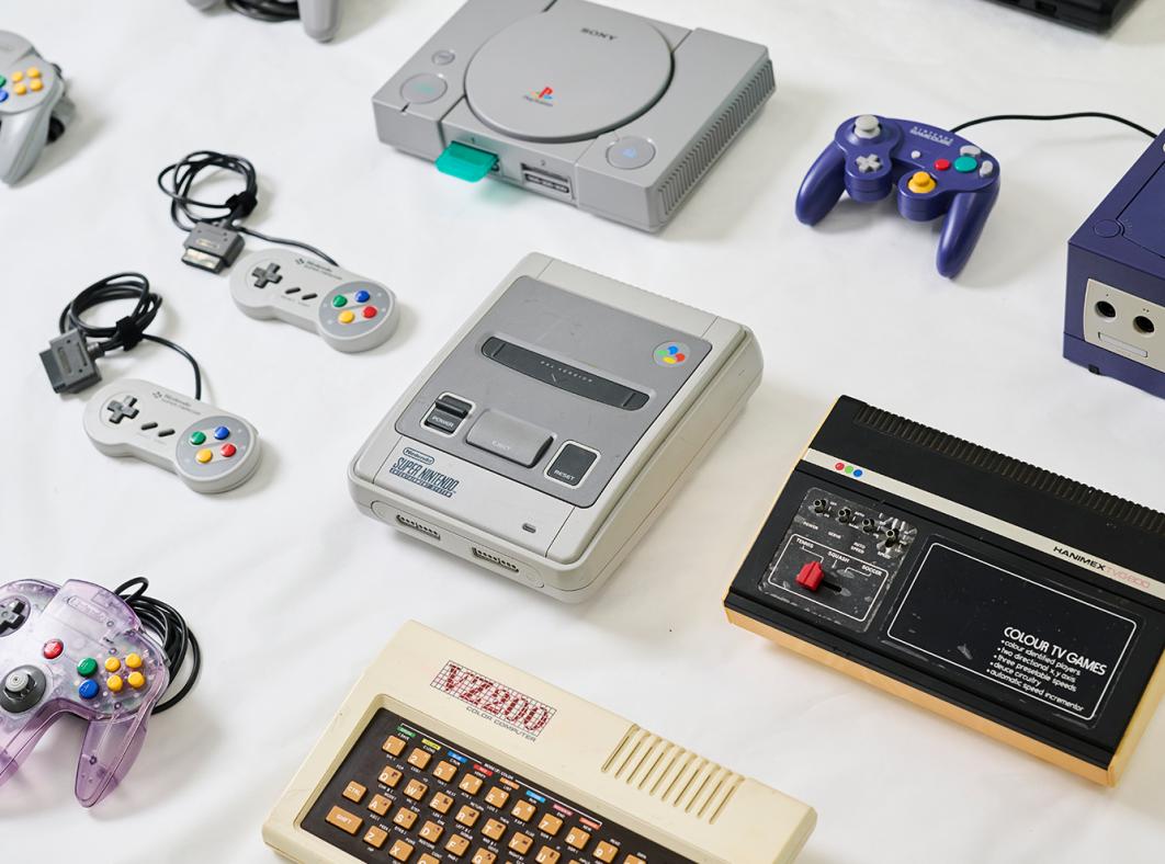 A collection of retro gaming consoles lined up on a table