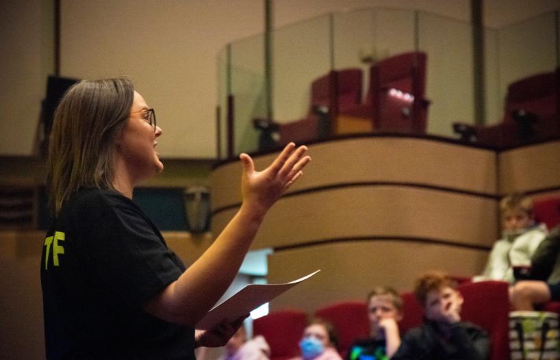 Woman speaking to an audience in a theatre