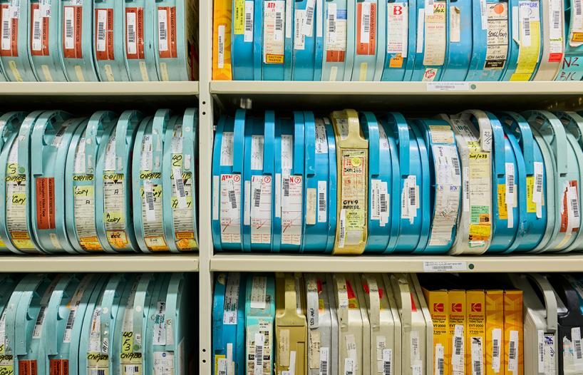 Full shelf of film reels in colourful containers