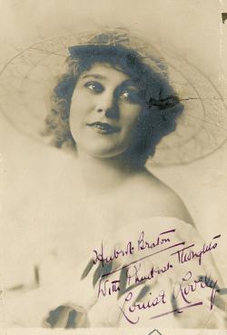 Louise Lovely signed fan photo with short hair and wearing a hat.