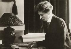 Percy Grainger writing at a desk