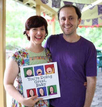 Beth Taylor holding a copy of the book 'You're Doing Great, Baby' with her partner Jeff Edwards