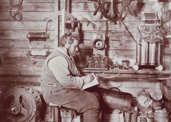 Wireless operator seated at his desk wearing headphones