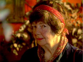 Margaret Olley looks askance at the camera wearing a red head scarf.