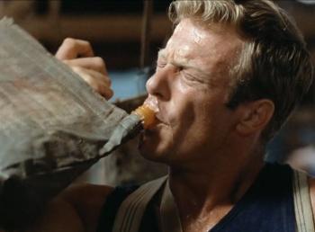Jack Thompson takes a swig from a hessian bag
