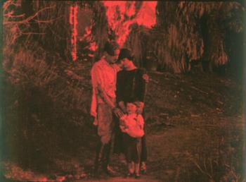 Image from the film  'Drifting' showing a man embracing a woman and child