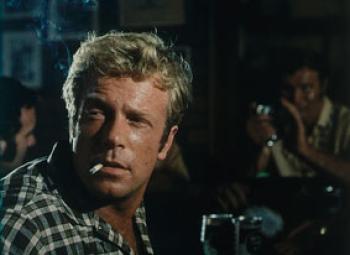 Jack Thompson as Joe turns to look past the camera with a cigarette in the corner of his mouth