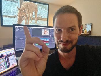 Samuel François-Steininger in his studio with a colourised image of a thylacine on his computer screen