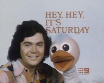 Close up of a man and a pink bird puppet. Above them is written 'Hey, Hey, It's Saturday' 