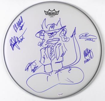 White drum head signed by members of AC/DC with an illusrration of Angus Young as a devil.