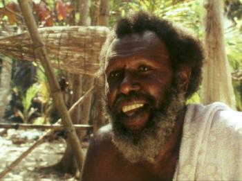Koiki Eddie Mabo smiling. Behind him is a traditional fishing trap used by his people on Mer (Murray Island) in the Torres Strait.