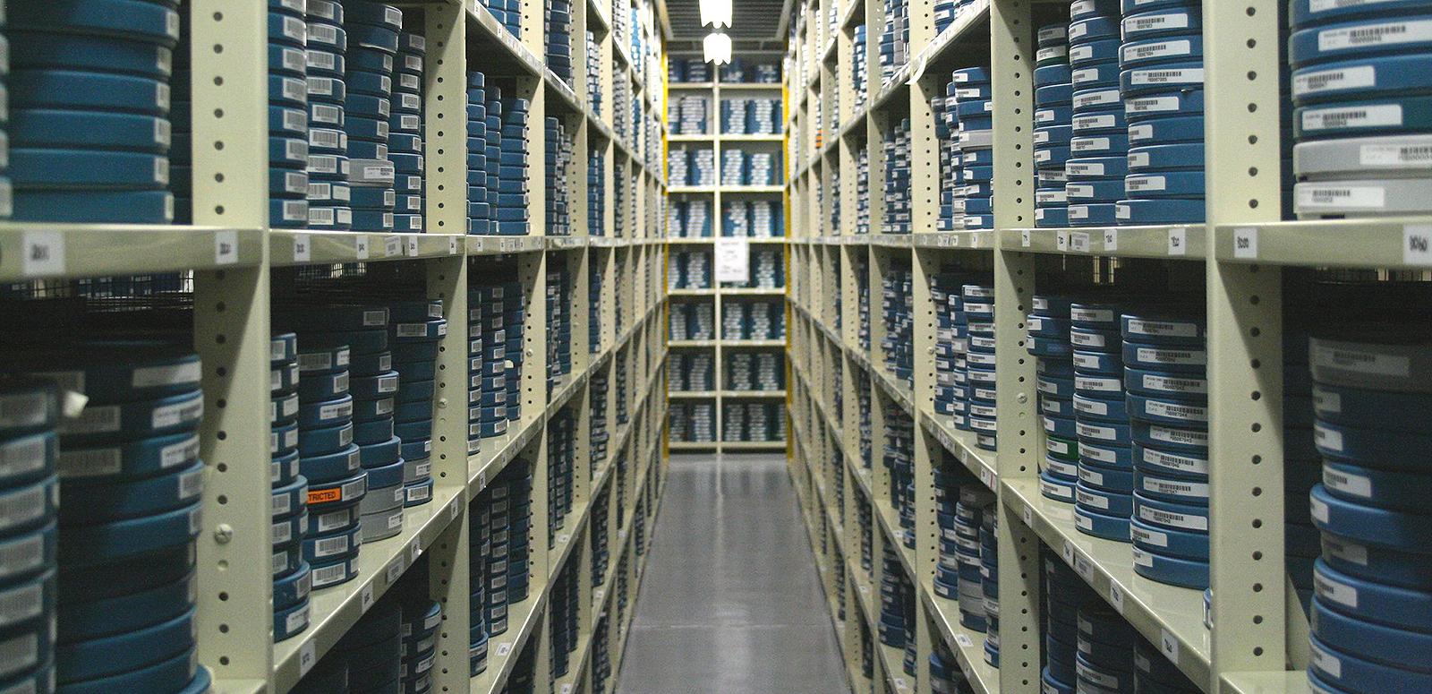 Shelves filled with stacks of film canisters in a vault at the NFSA