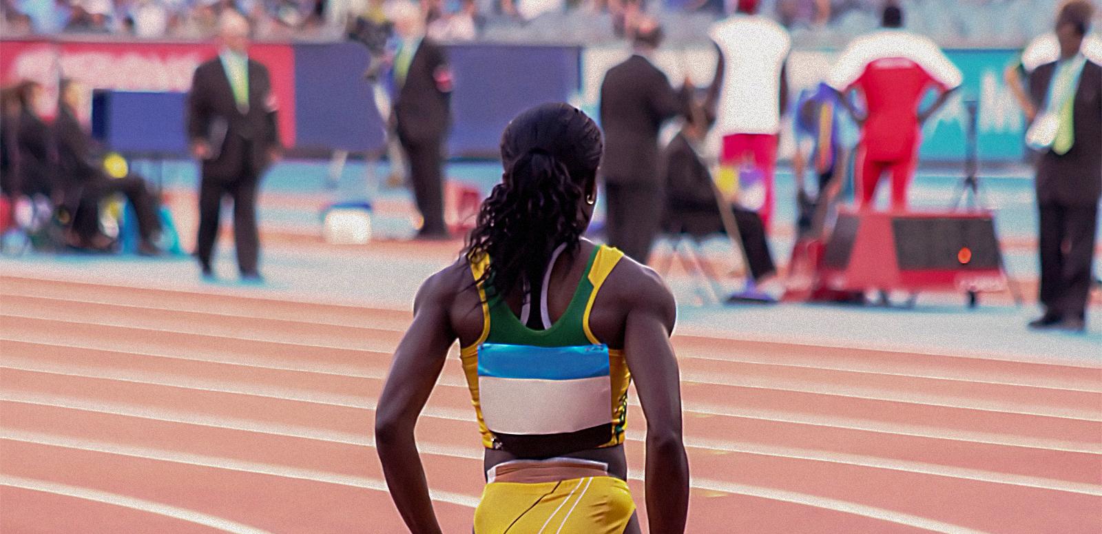 Back view of a female athlete standing on the running track.