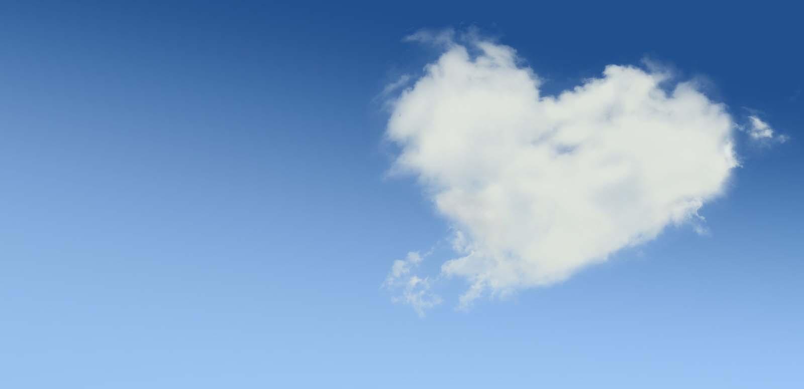 A heart-shaped cloud against a blue sky