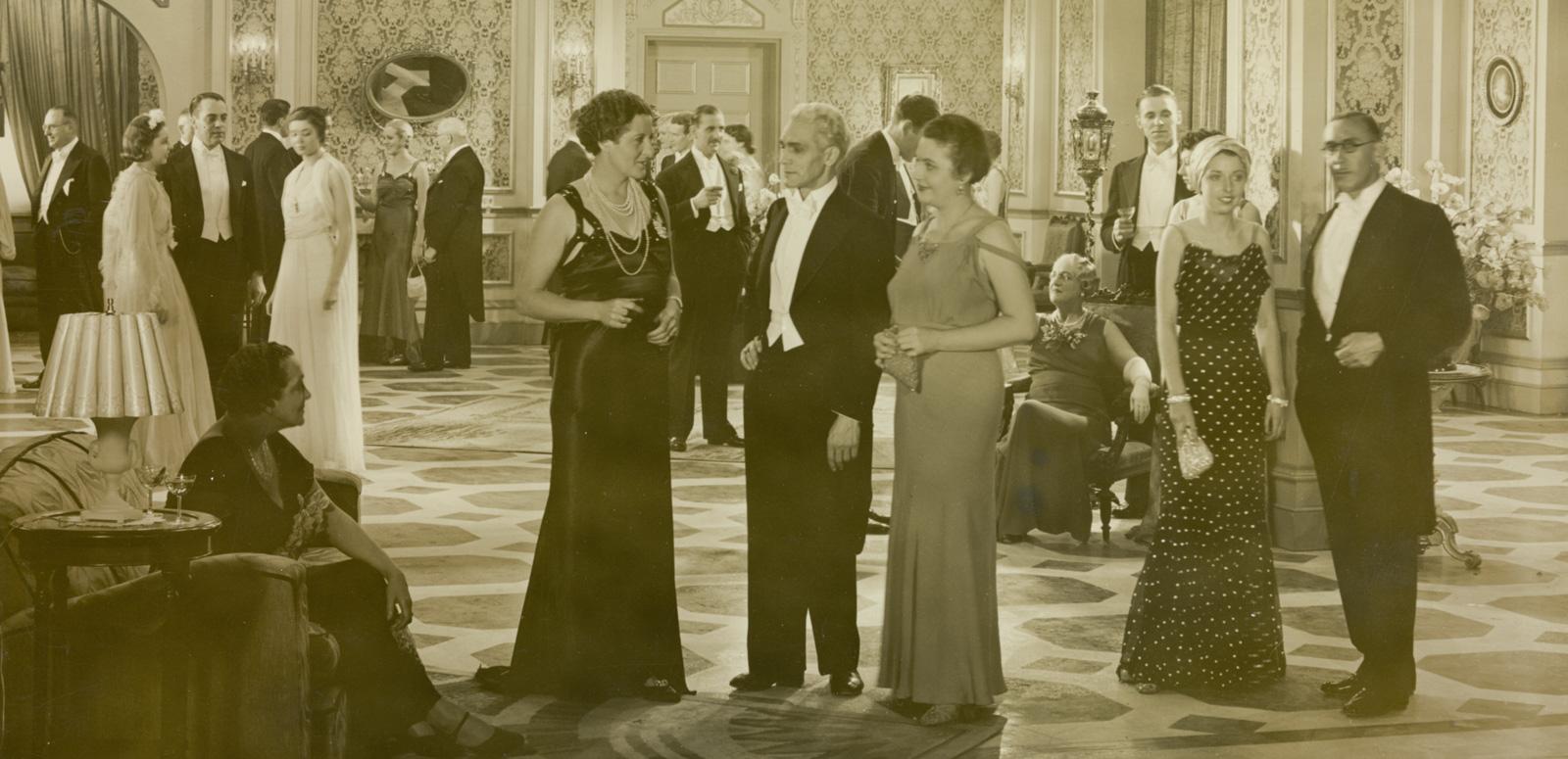 A large ballroom full of people in elegant clothing.