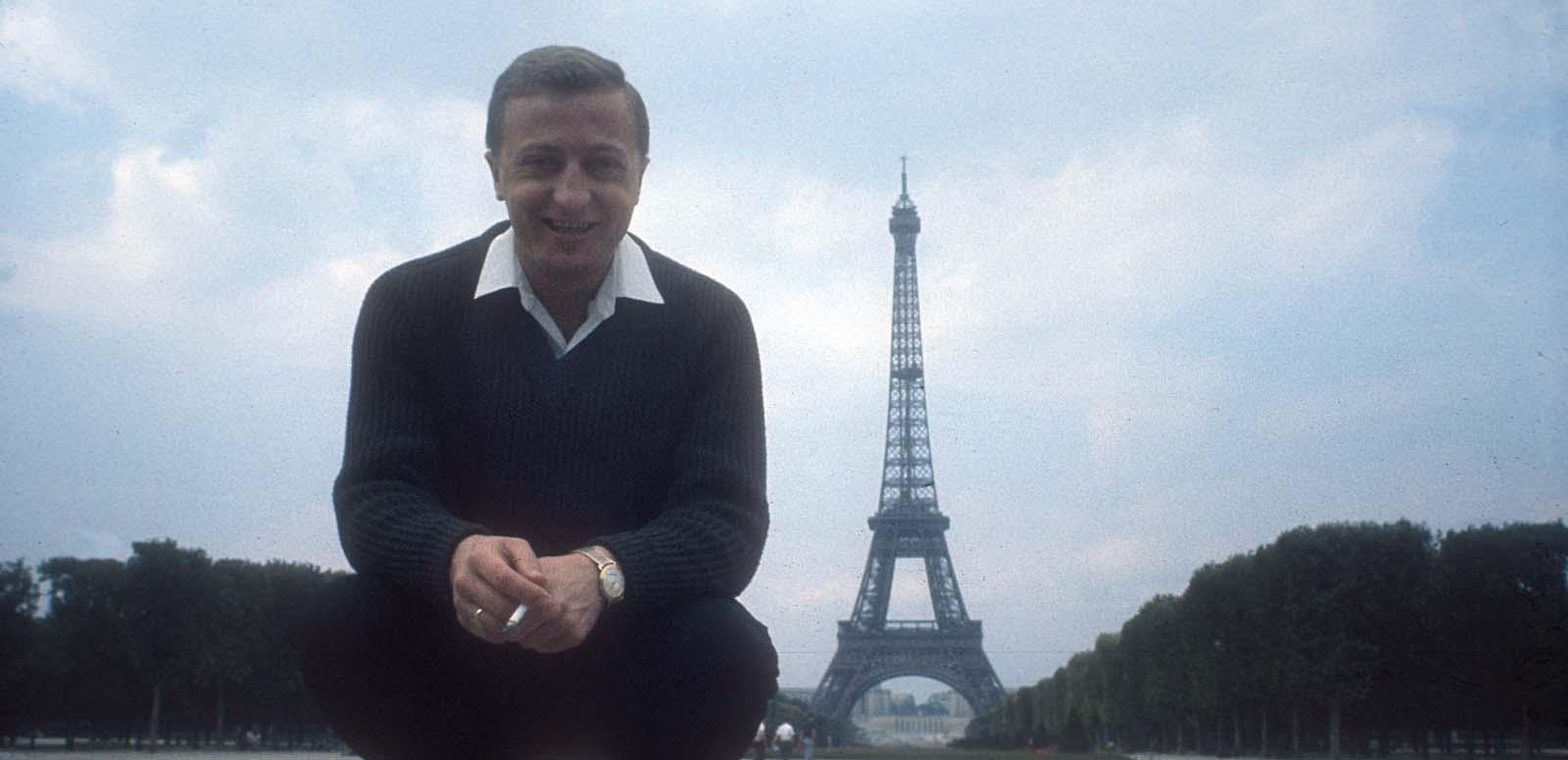 Graham Kennedy poses for the camera in Paris with the Eiffel Tower in the background