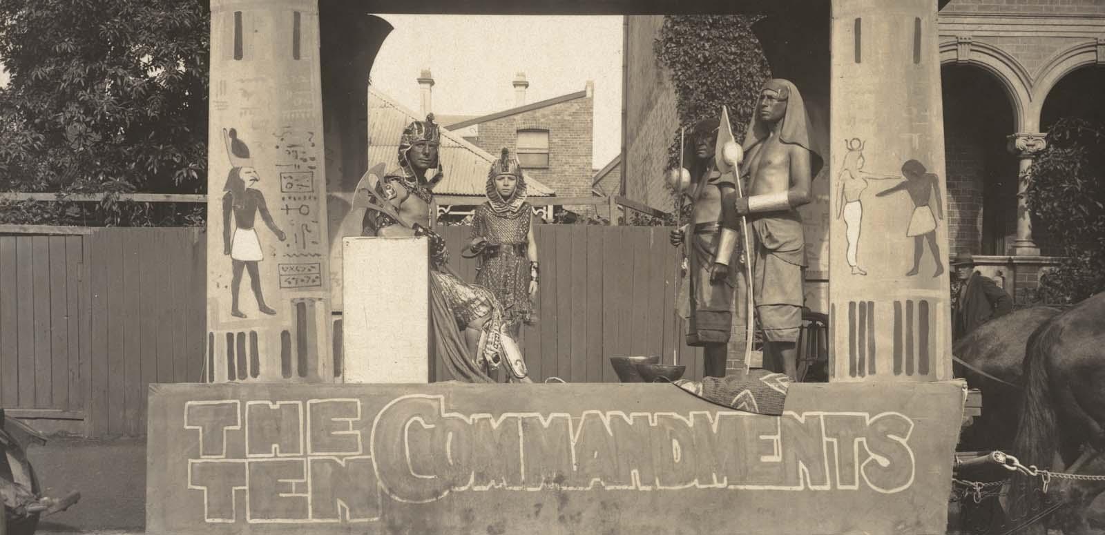 Four actors in costume pose on a horse-drawn trailer promoting The Ten Commandments in 1925
