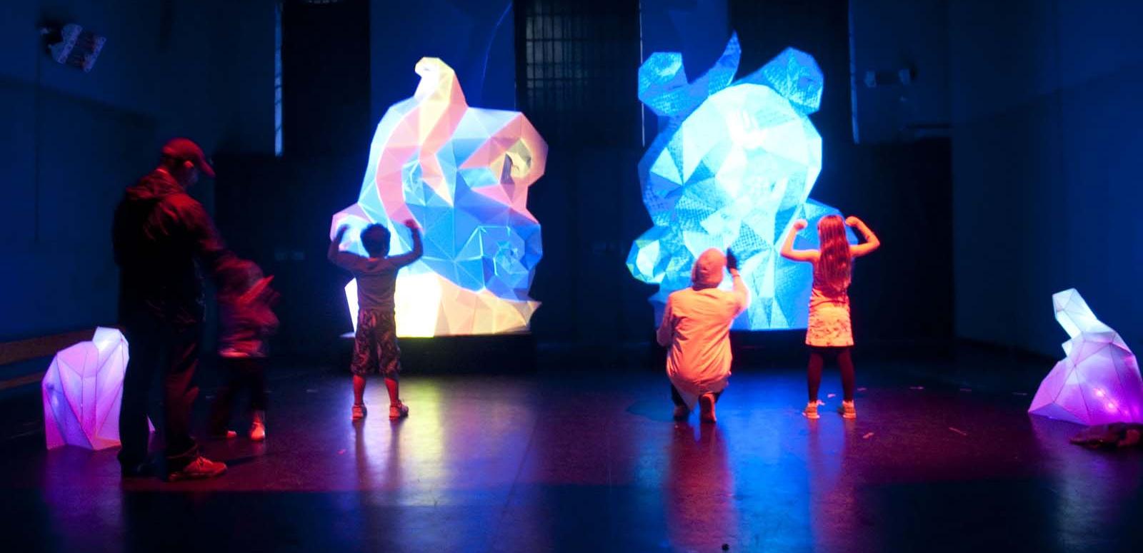 Children stand in front the interactive light sculpture Fractured Heart at the NFSA