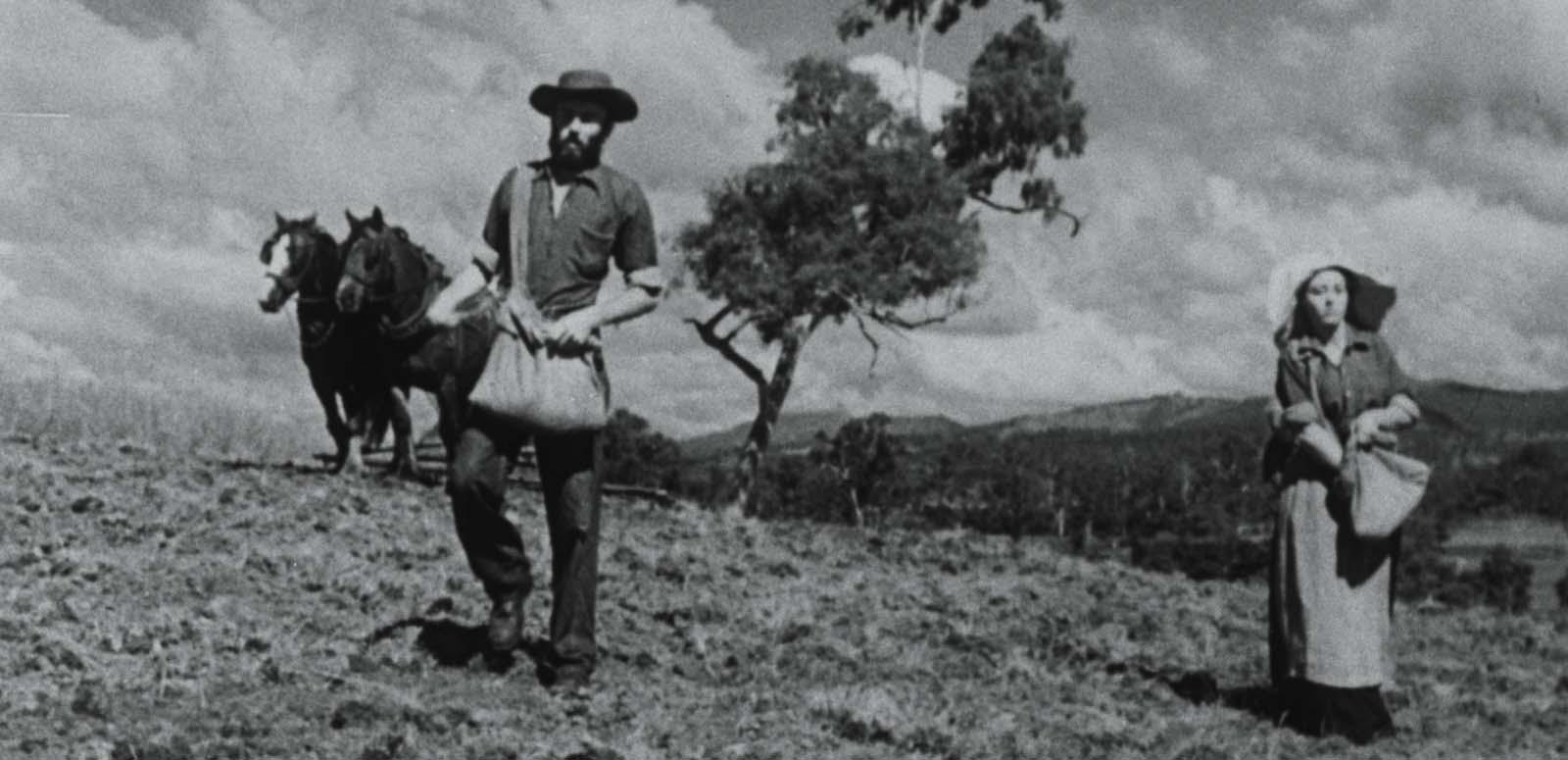 A man and woman sow seeds on an outback farm in a still from the 1949 film Sons of Matthew