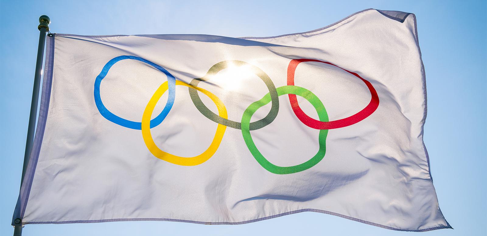 The Olympic flag against a blue sky