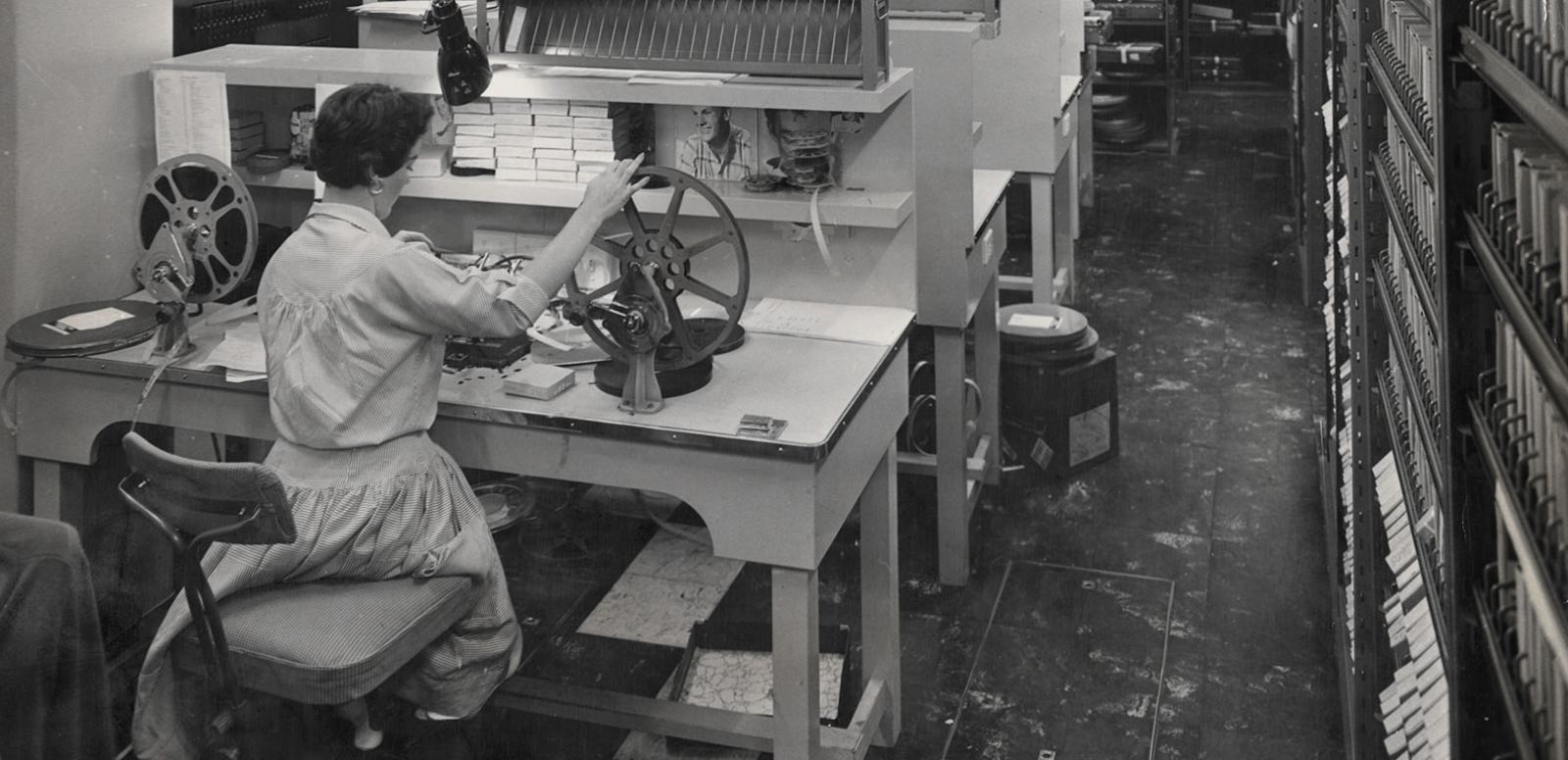 A woman operating a film winder at a film winding bench at Channel 7, Sydney. Circa 1950s. 
