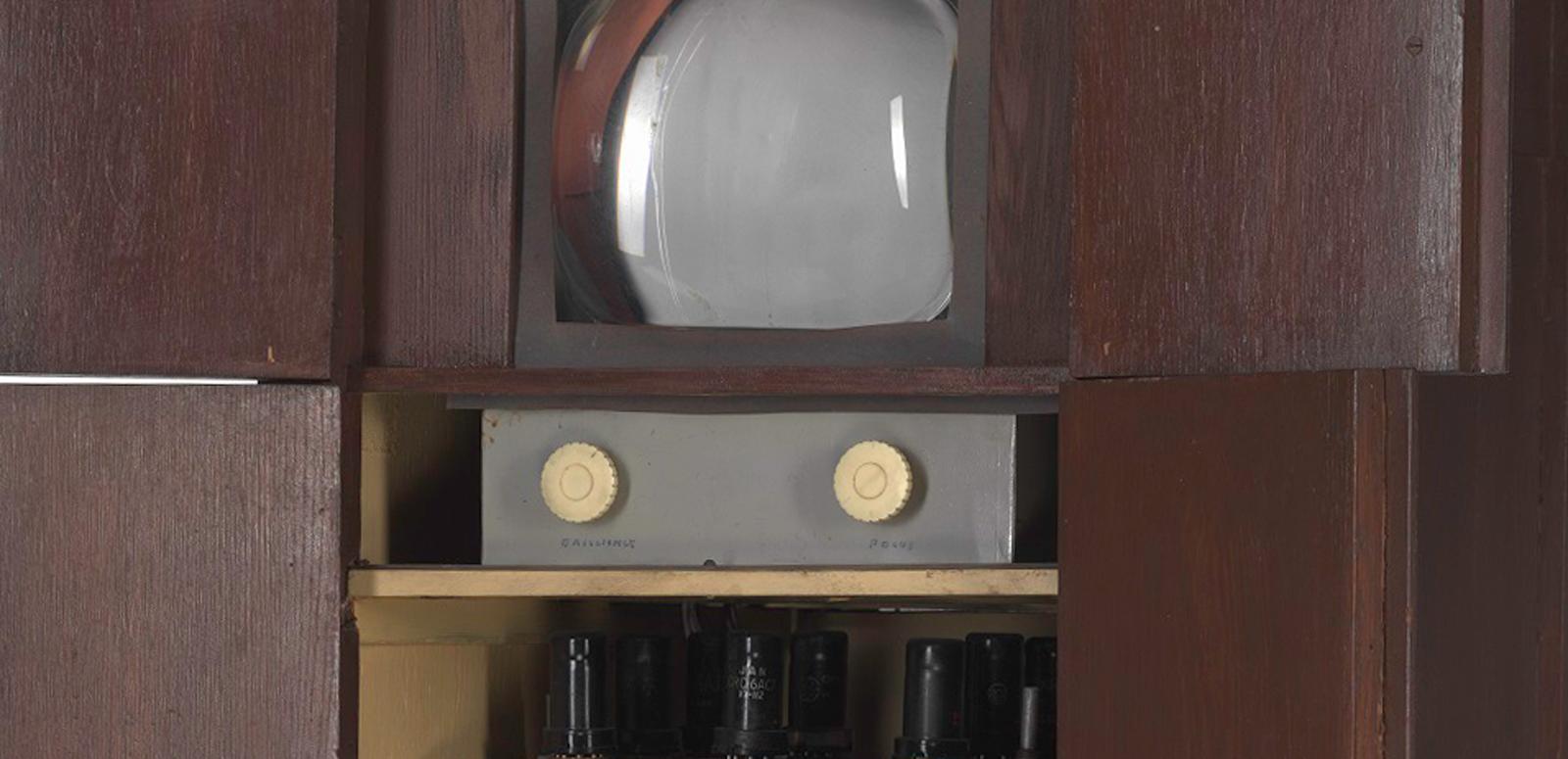 Close up of Sid Oldroyd's homemade TV showing screen and dials inside a wooden cabinet, built in 1956.