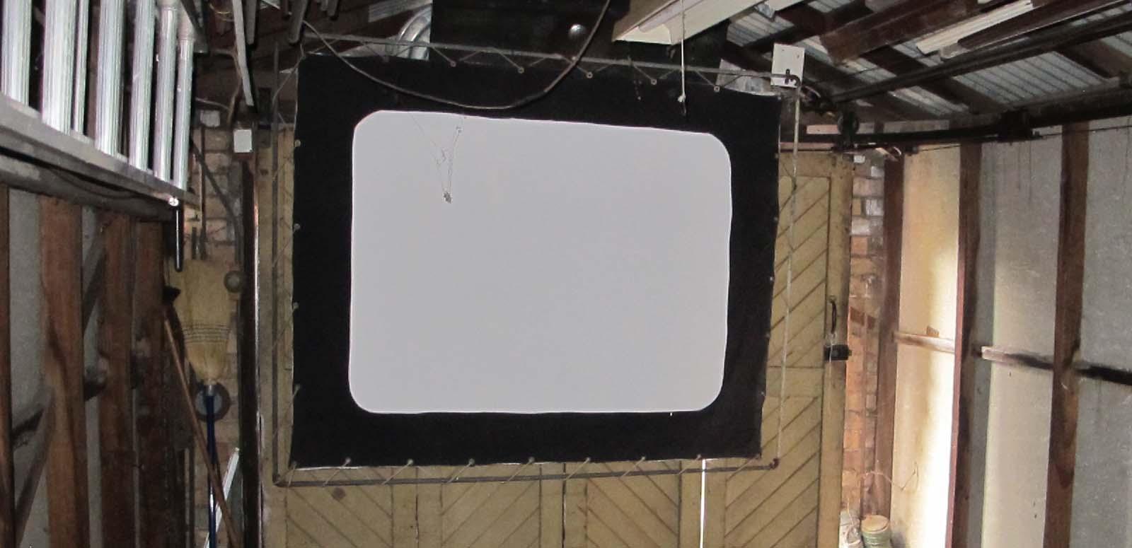 A screen hanging in a garage in Wollongong, part of the 1940s home cinema set-up of film projectionist Eddie Vormister