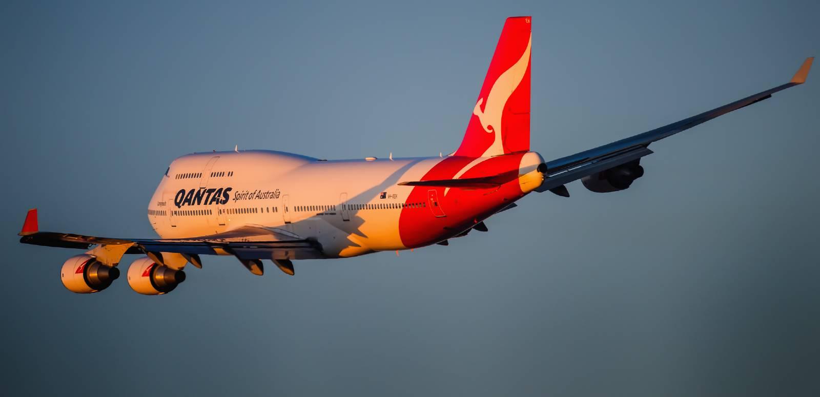 A passenger aircraft Boeing 747-400 in Qantas colour scheme taking off from Kingsford Smith airport