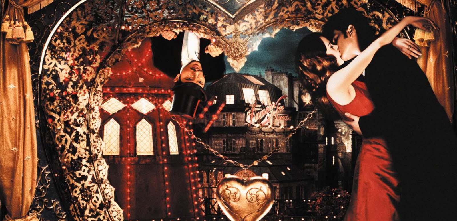 Satine and Christian embrace in her chambers while Toulouse-Lautrec peers down at them from outside a heart-shaped window, in a scene from Moulin Rouge!
