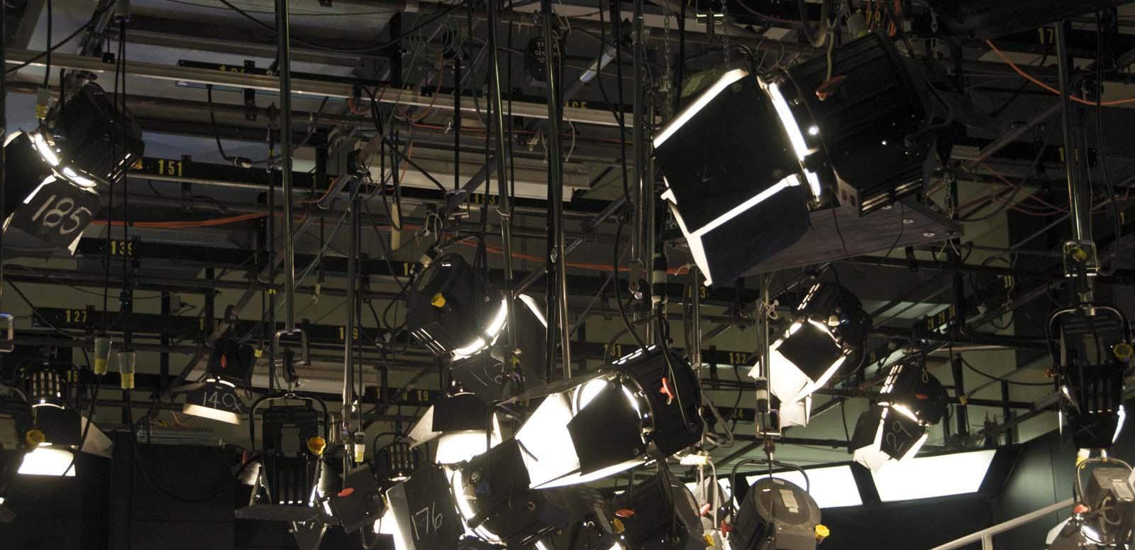 An array of studio lights suspended from the ceiling of a TV studio