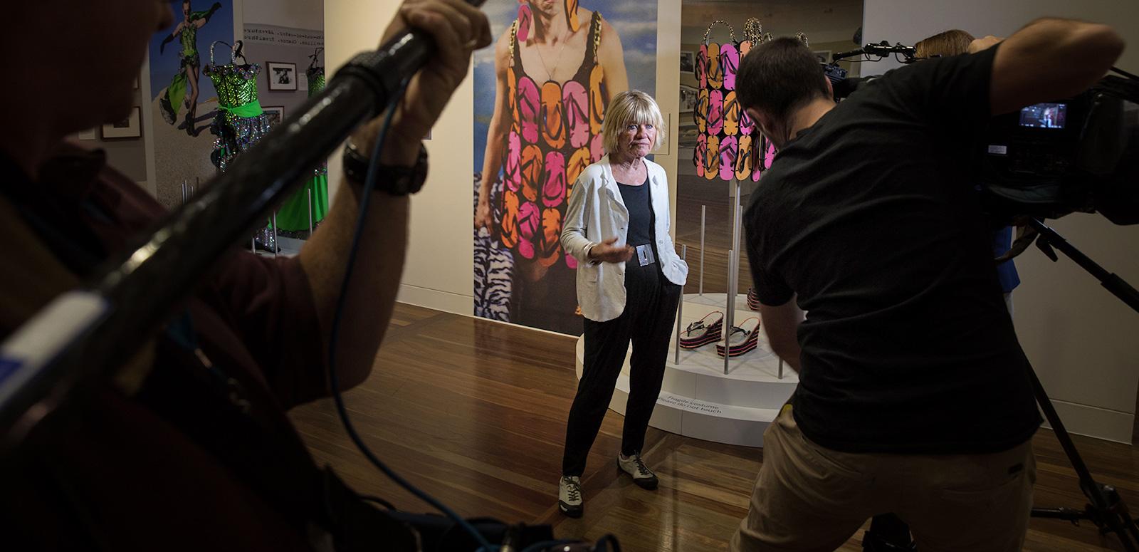 Margaret Pomeranz at the Starstruck exhibition. She's posing with the Priscilla thong dress for a TV crew.