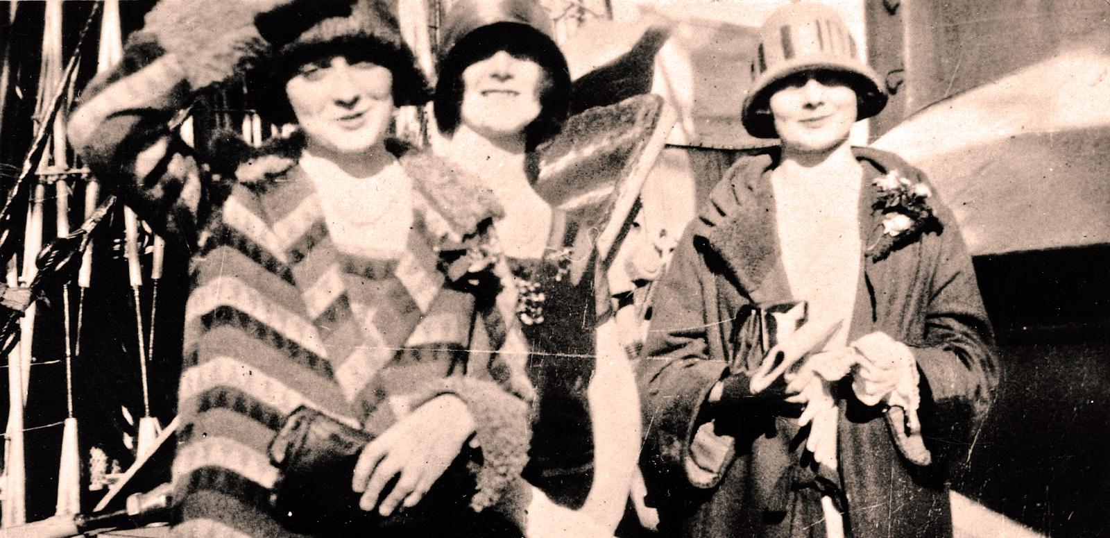 The McDonagh sisters, Isabel, Paulette and Phyllis, pictured from the waist up, wearing coats and hats and standing on the deck of a ship.