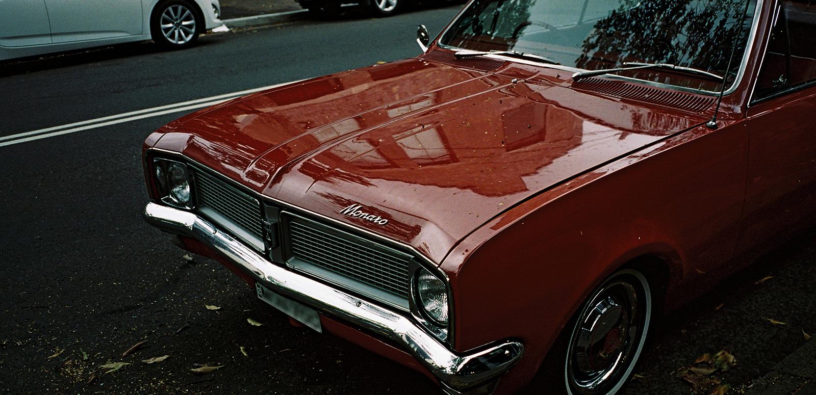 The front grill and bonnet of a red Holden Monaro car.