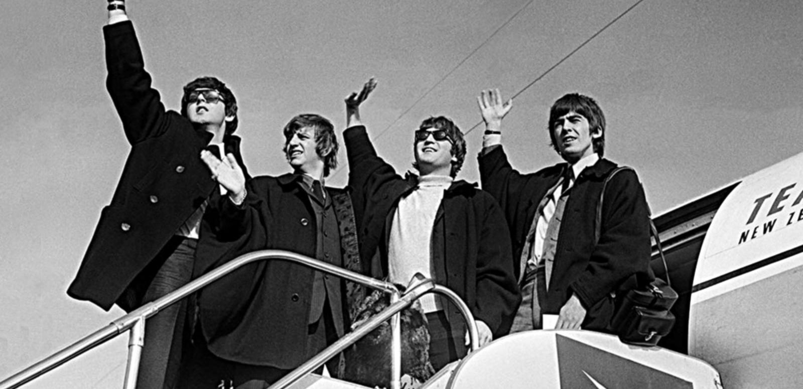 The Beatles (from left to right: Paul McCartney, Ringo Starr, John Lennon, George Harrison) wave to crowds in Sydney as they prepare to board a plane to New Zealand in June 1964.