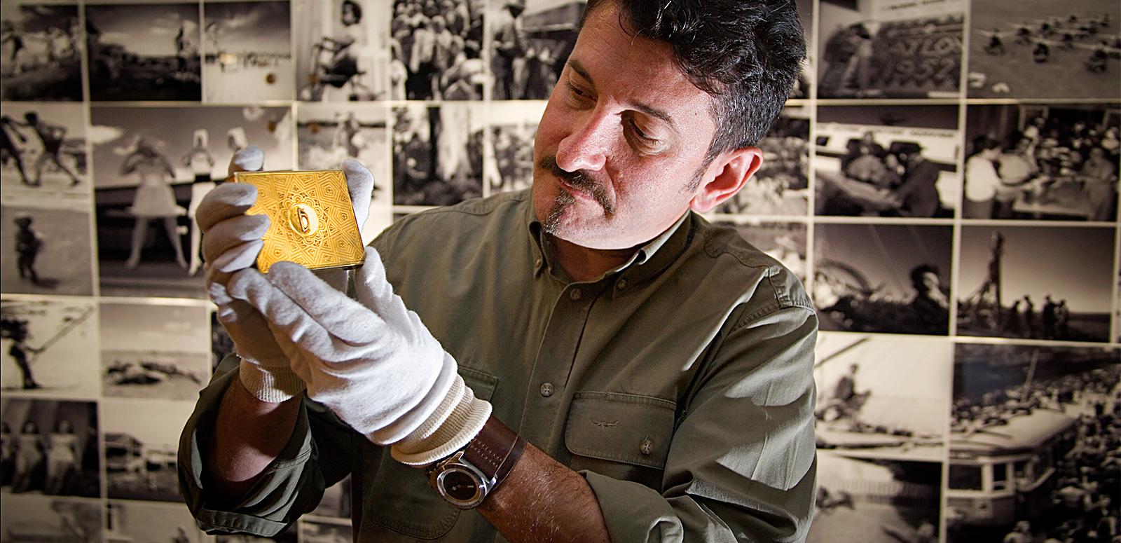 Warren Brown holds up a gold cigarette case at the National Archives of Australia